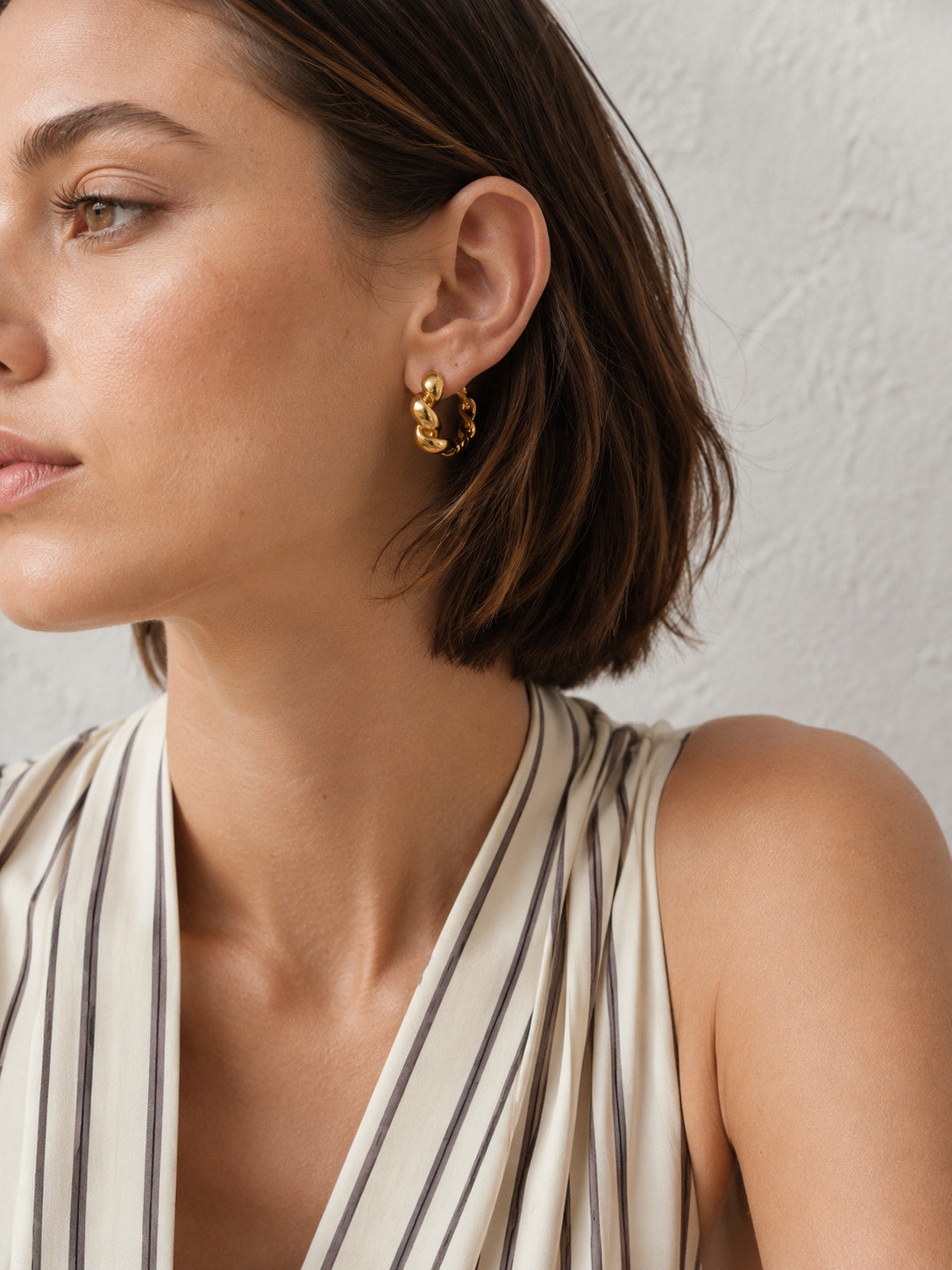 Close-up of gold twisted hoop earrings styled for everyday wear