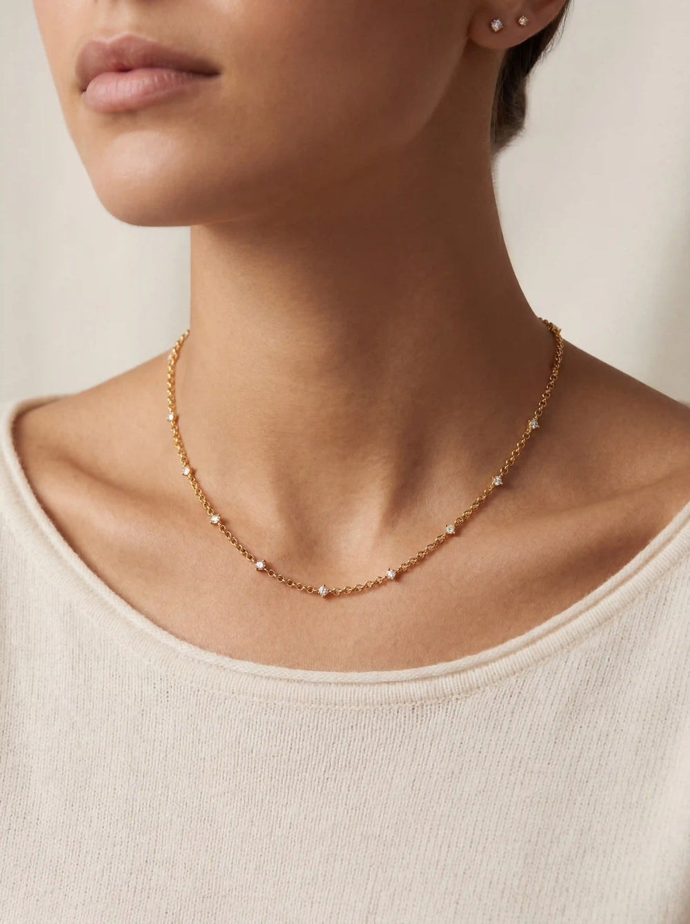 Close up of woman wearing delicate gold Elara crystal station necklace minimalist collarbone jewelry.