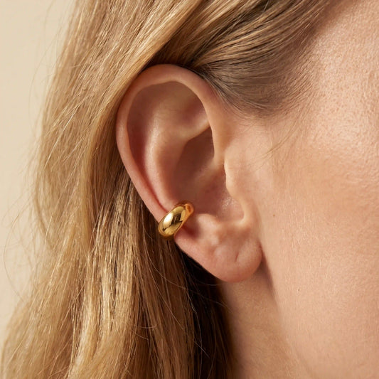 Close up of woman wearing thick gold Eos dome ear cuff cartilage jewelry no piercing needed.