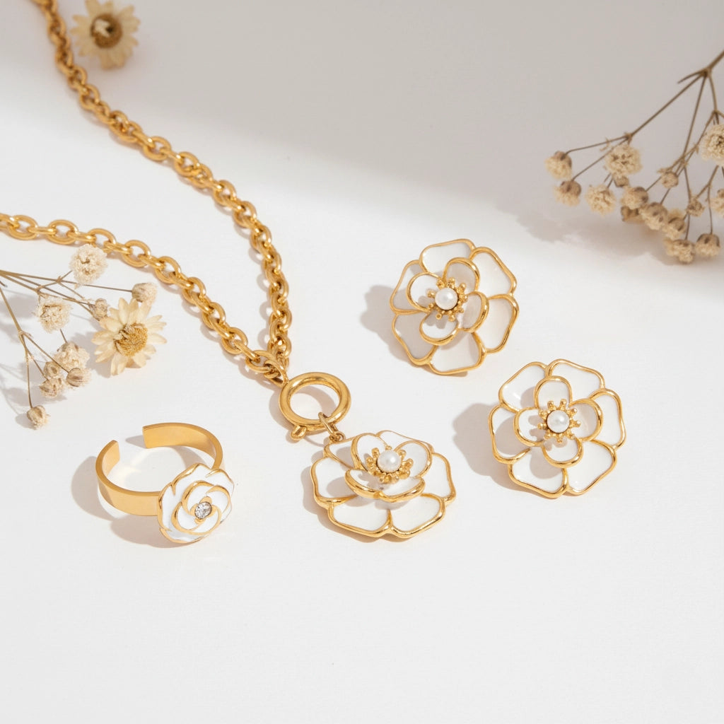 The complete Fleur Collection, featuring the camellia flower pendant, the matching Fleur Studs earrings, and the Fleur Ring, displayed together.