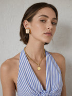Gold coin toggle necklace and square dome earrings worn together