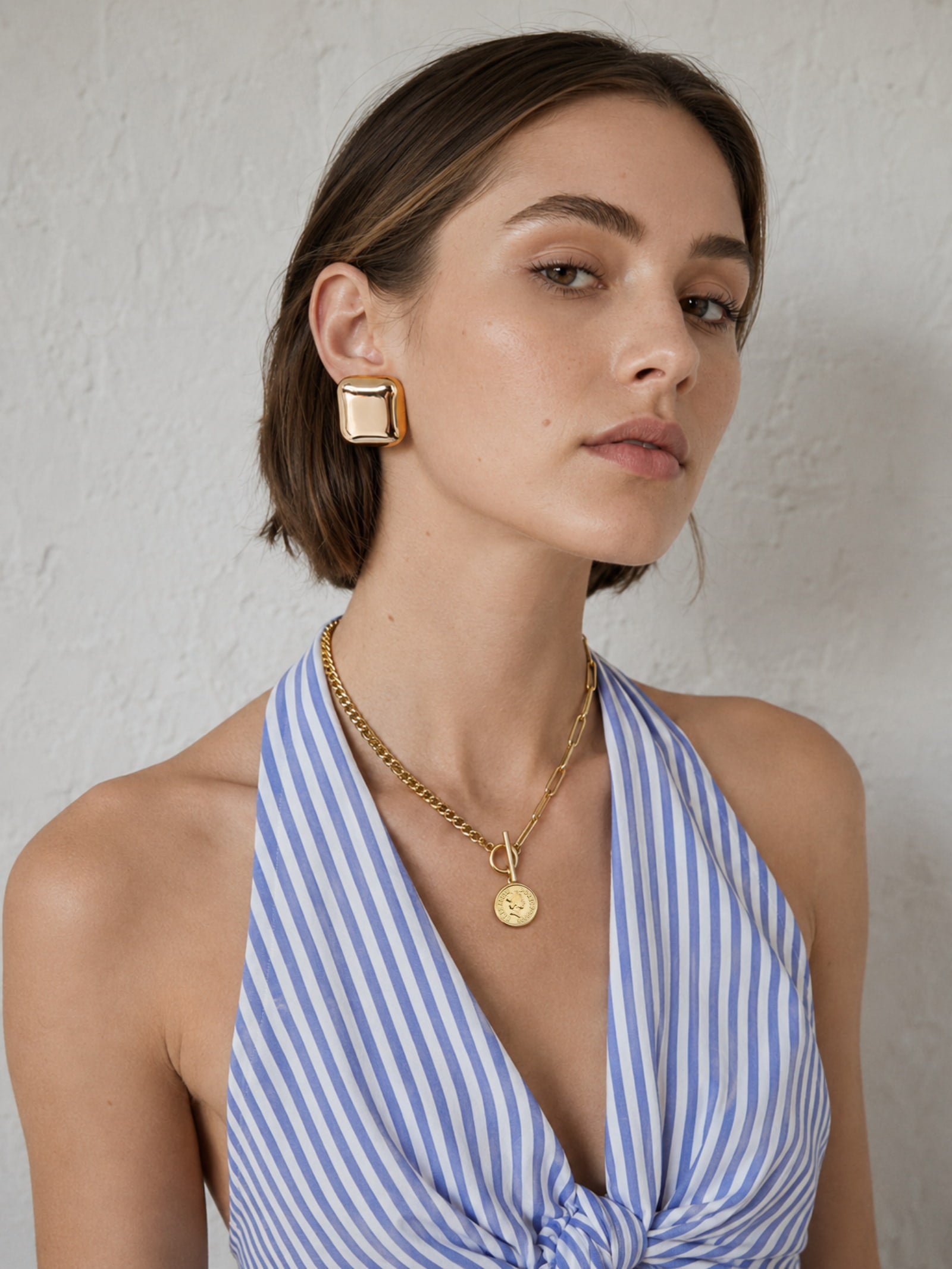 Gold coin toggle necklace and square dome earrings worn together