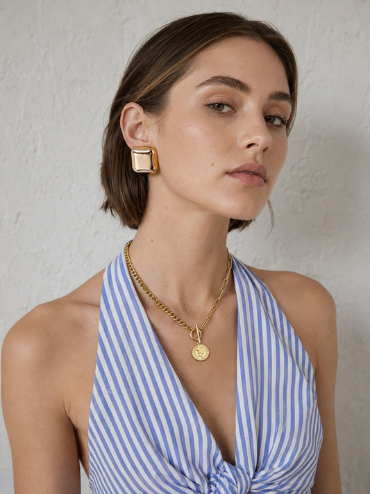 Gold coin toggle necklace and square dome earrings worn together