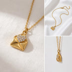 Aesthetic product photography details of gold love note envelope necklace with crystal heart.