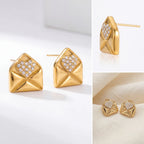 Aesthetic product photography of gold love letter stud earrings details on white background.