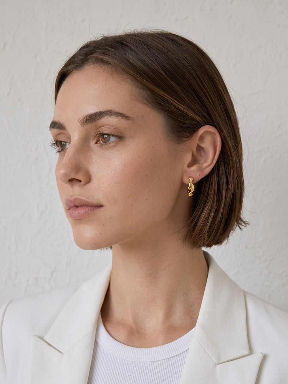 Nola Organic Wave Hoops styled on the ear with a polished sculptural profile