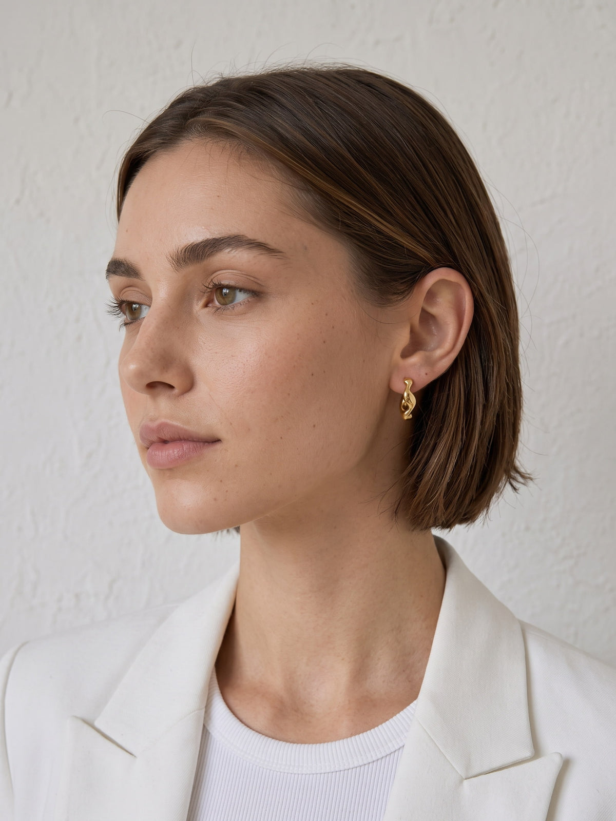 Nola Organic Wave Hoops styled on the ear with a polished sculptural profile