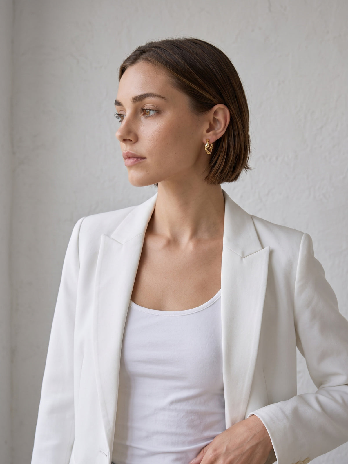 Nola Organic Wave Hoops styled on the ear, showing the compact sculptural hoop shape