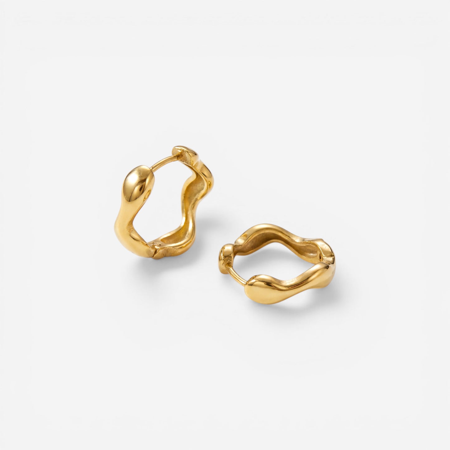 18k gold plated stainless steel organic hoops, abstract wavy shape earrings, water-resistant sculptural jewelry isolated on white background.