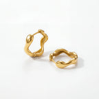 18k gold plated stainless steel organic hoops, abstract wavy shape earrings, water-resistant sculptural jewelry isolated on white background.