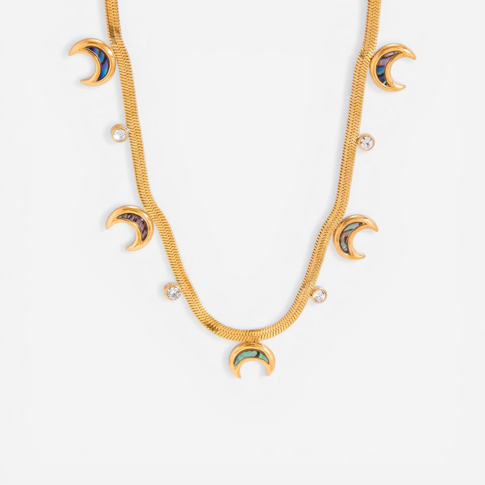 Close up detail of gold textured snake chain necklace with iridescent abalone shell crescent moon charms.