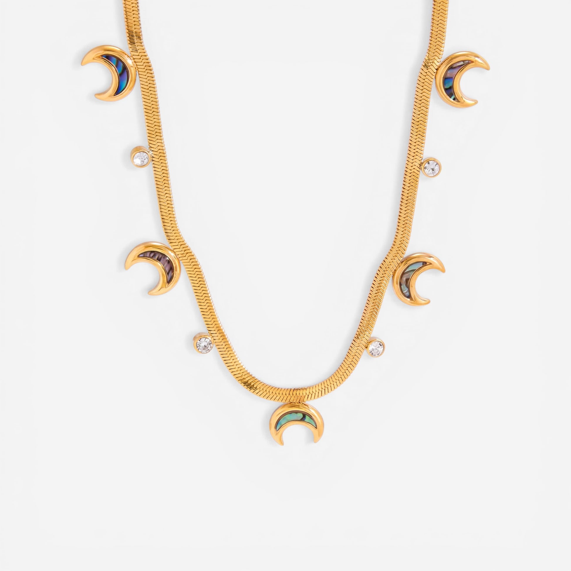 Close up detail of gold textured snake chain necklace with iridescent abalone shell crescent moon charms.