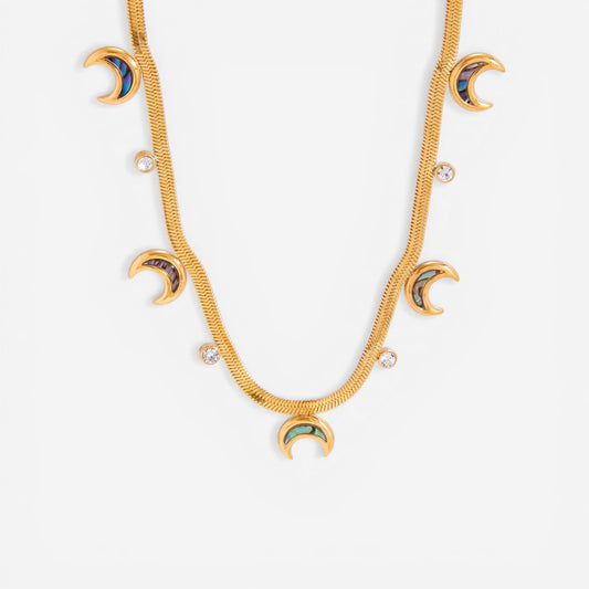 Close up detail of gold textured snake chain necklace with iridescent abalone shell crescent moon charms.