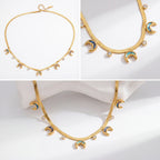 Aesthetic product photography of gold celestial moon necklace with colorful abalone inlay on white stone.