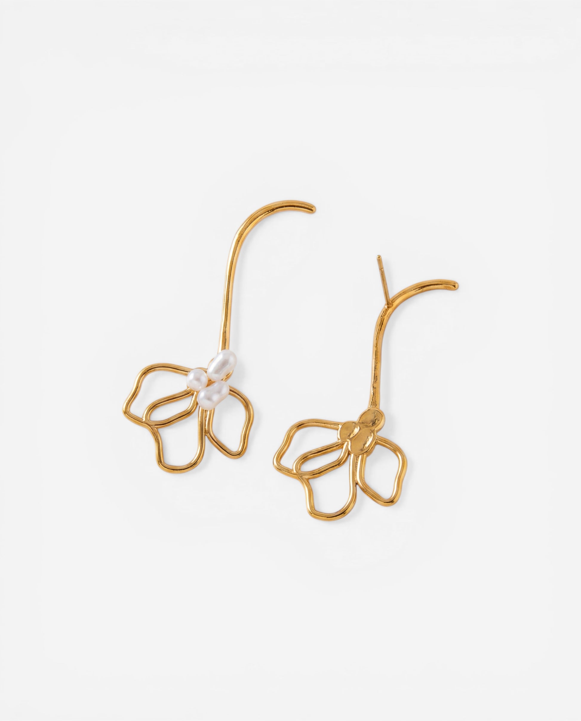 Gold long curved stem earrings with hollow petal shape and simulated pearls on white background.