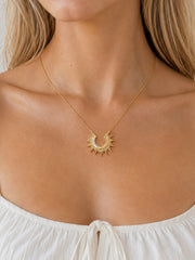 Model wearing the Radiant Sunburst Arc Necklace with zircon accents at the collarbone
