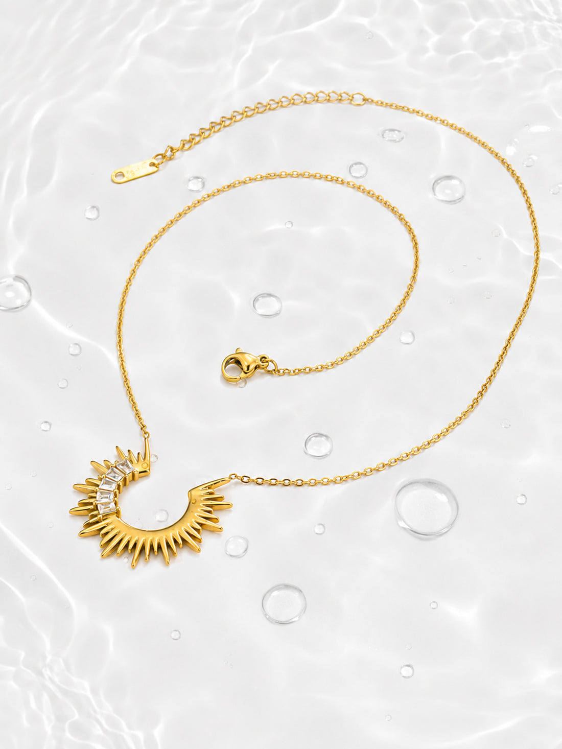Detail view of the Radiant Sunburst Arc Necklace showing asymmetrical baguette-cut zircon accents