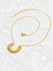 Detail view of the Radiant Sunburst Arc Necklace showing asymmetrical baguette-cut zircon accents