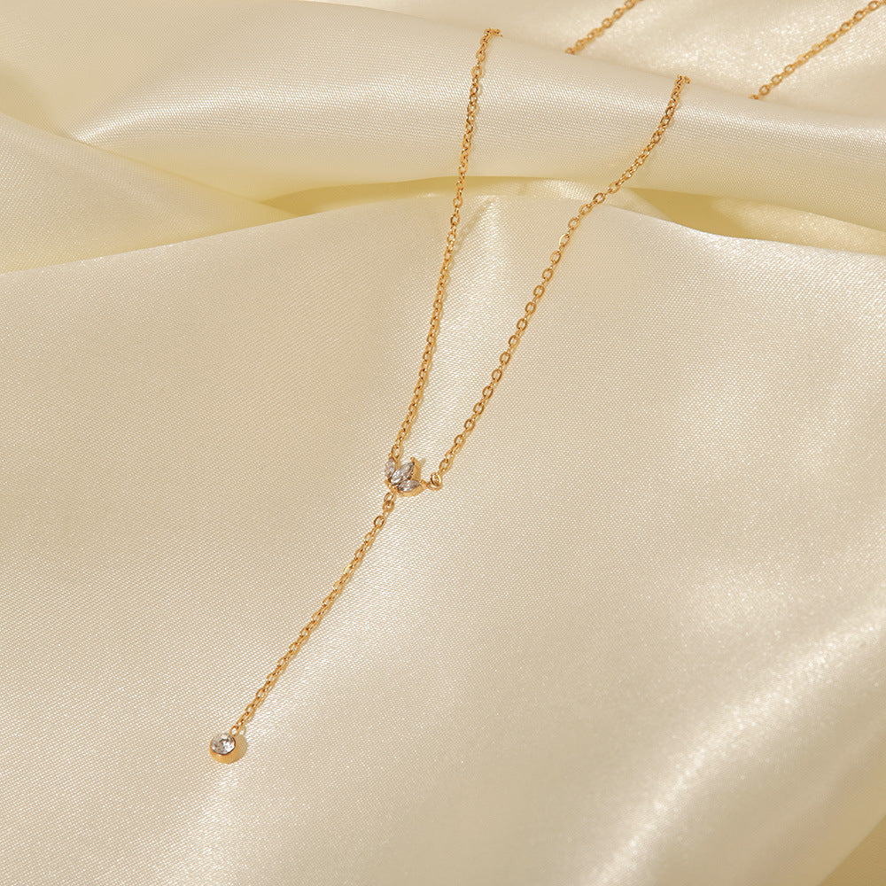 A macro close-up of the dainty, sparkling crystal crown pendant on The Reine Necklace, showcasing the intricate pavé setting.