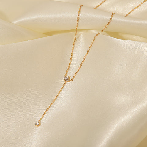 A macro close-up of the dainty, sparkling crystal crown pendant on The Reine Necklace, showcasing the intricate pavé setting.