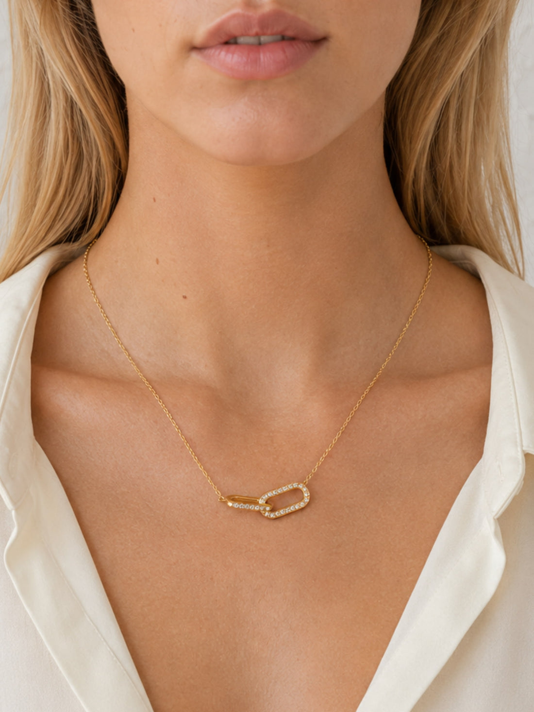 Model wearing the Sculpted Ribbon Heart Necklace with a white shirt