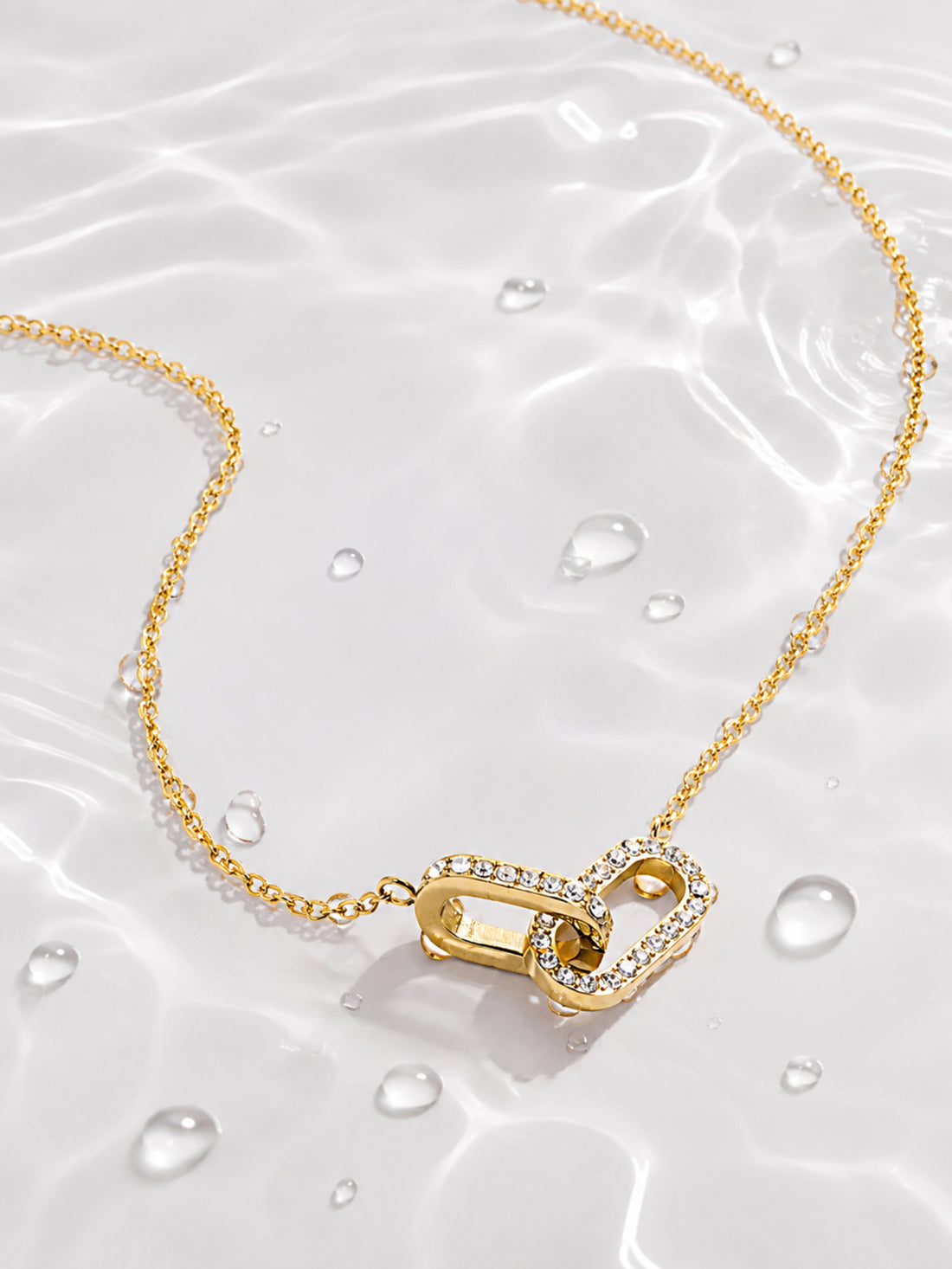 Detail view of the asymmetrical ribbon heart pendant with clear zircon accents