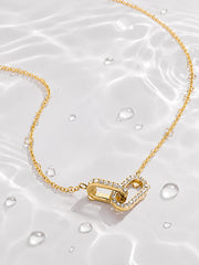 Detail view of the asymmetrical ribbon heart pendant with clear zircon accents
