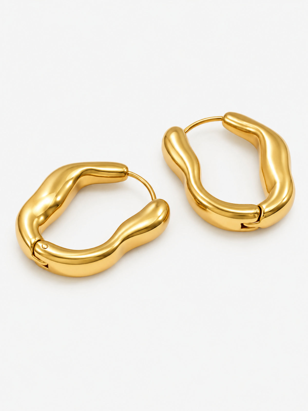 Sculpted Wave Huggie Hoop Earrings in polished gold on a clean white background