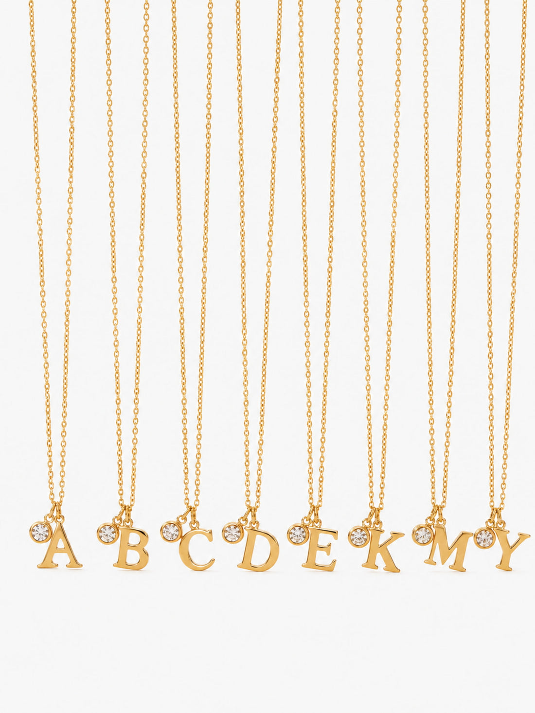 Gold initial and clear zircon pendant necklace on a clean white background