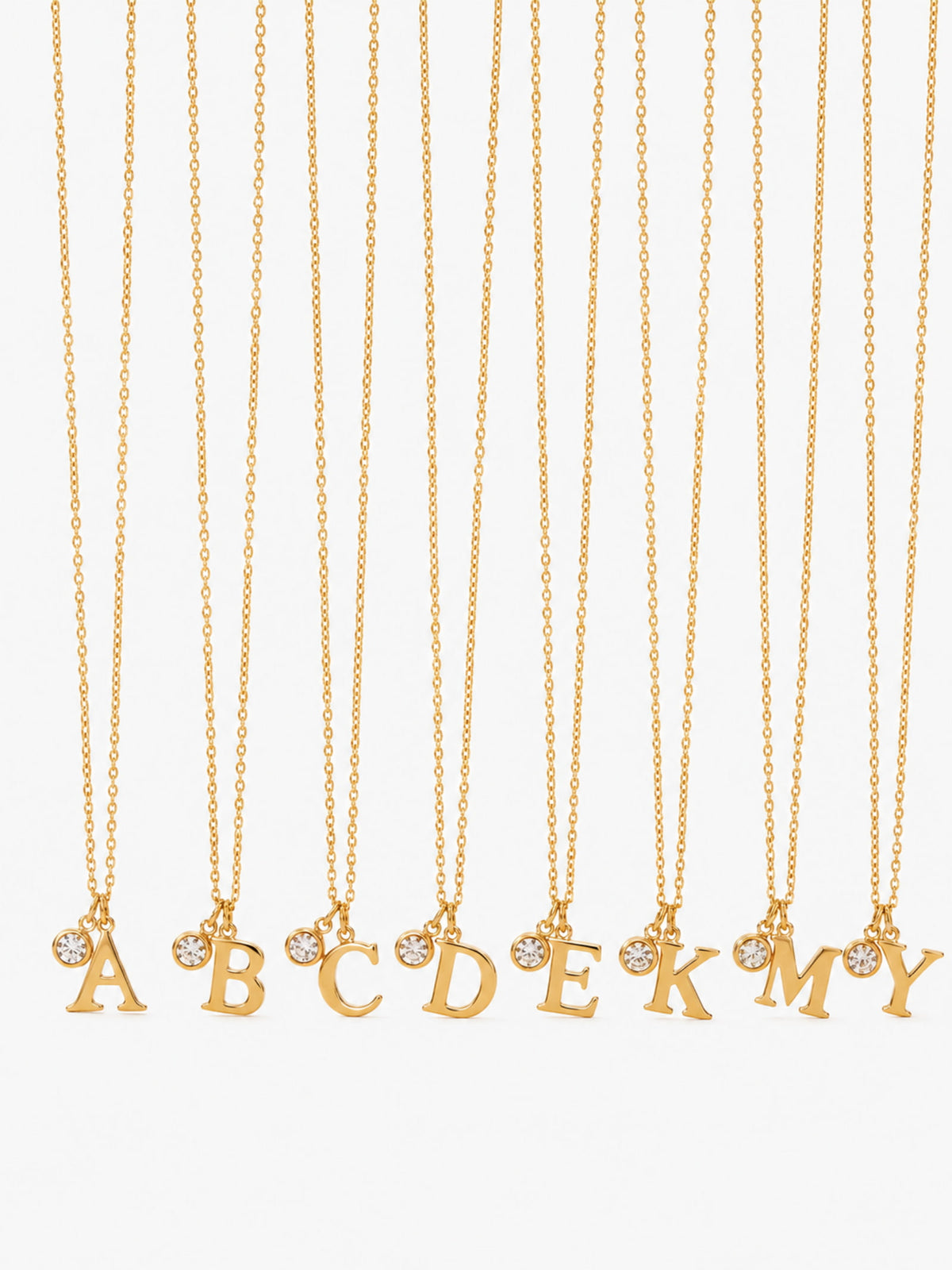 Gold initial and clear zircon pendant necklace on a clean white background