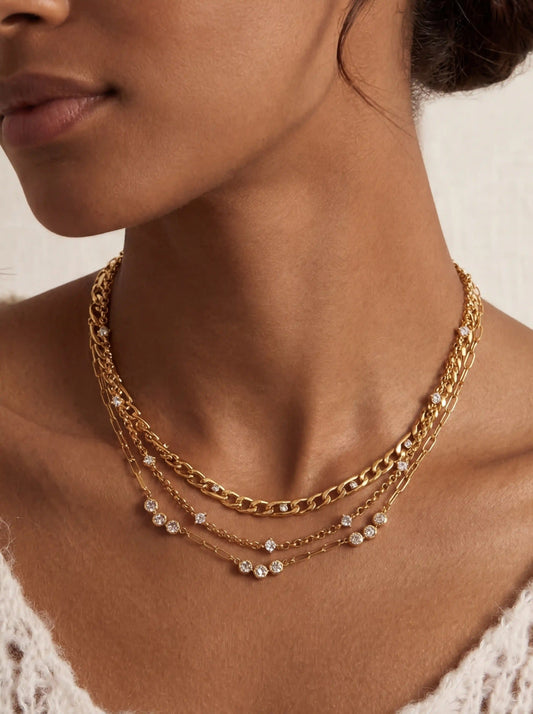 Close up of dark skin model wearing The Starlight Layering Trio perfectly curated 3-piece gold necklace stack.
