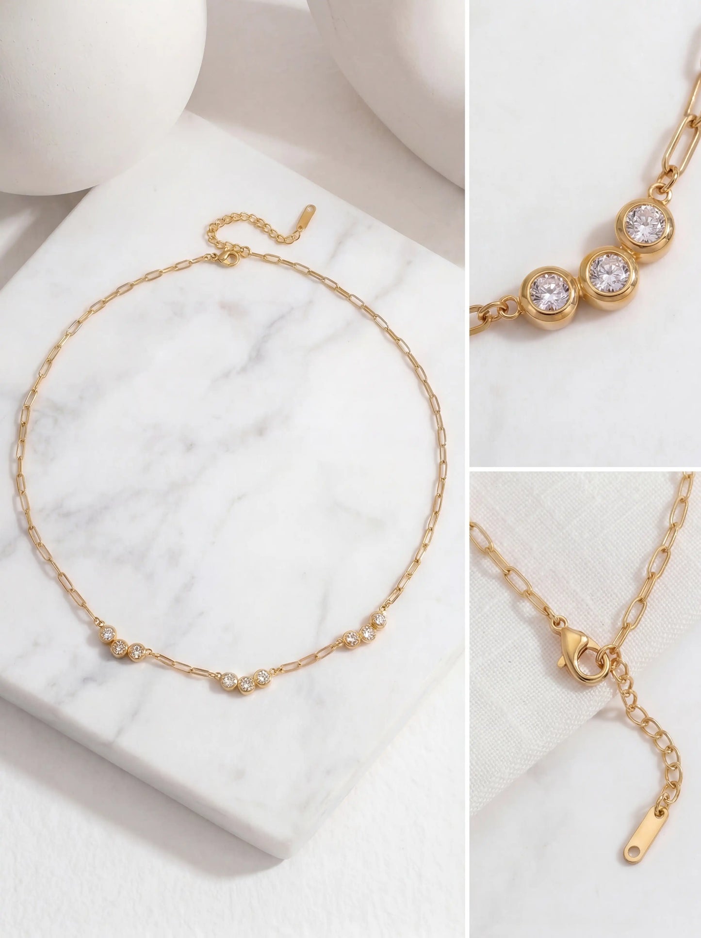 Aesthetic product photography details of gold paperclip chain and triple crystal pendant on white marble.