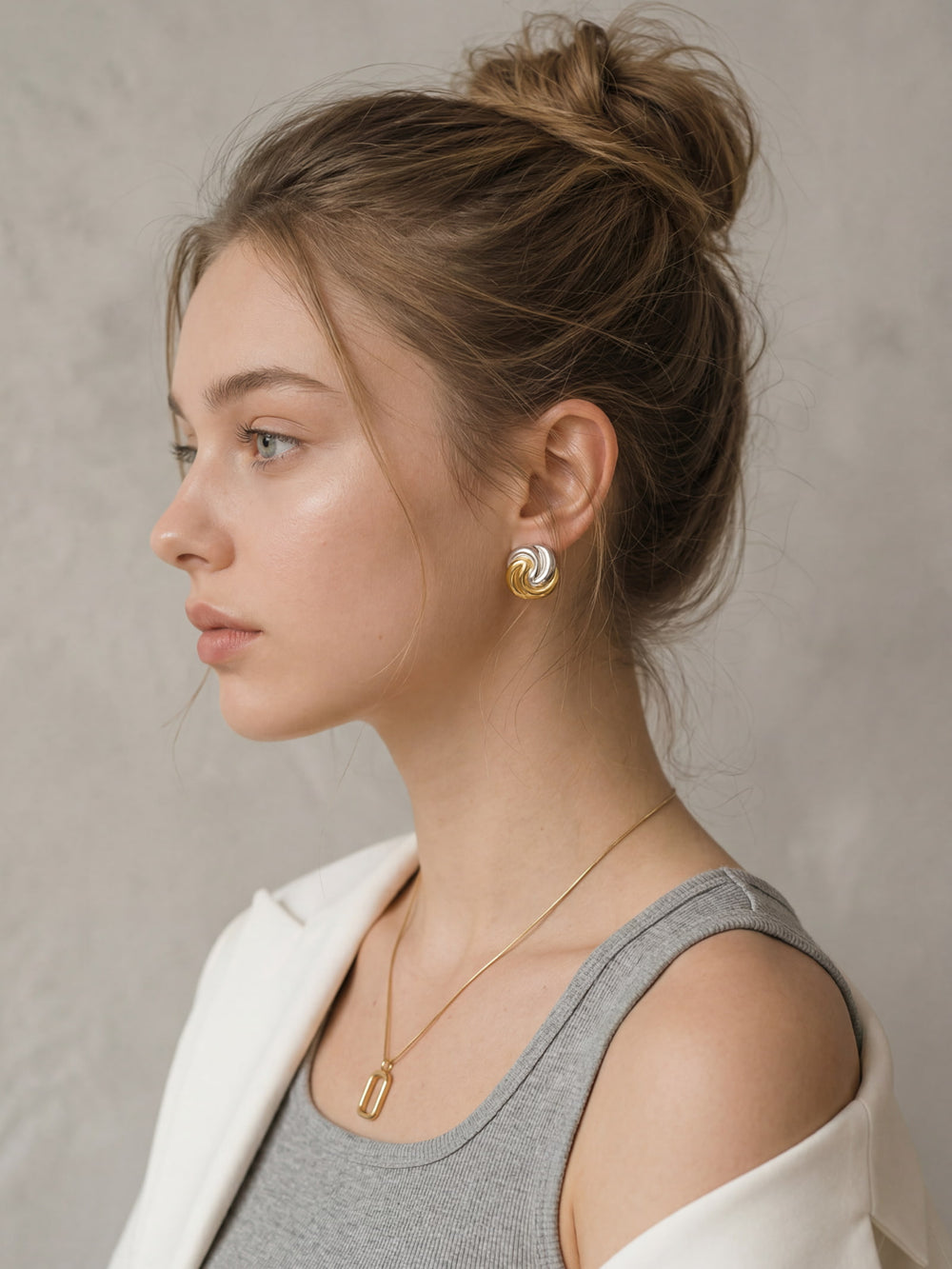 Gold and silver swirl earrings styled with everyday neutral outfit