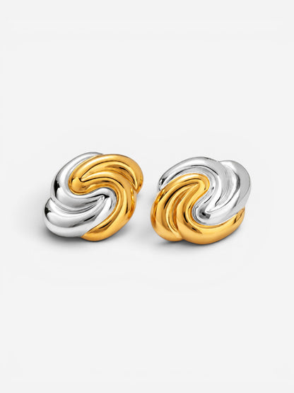 Gold and silver two-tone swirl earrings on white background