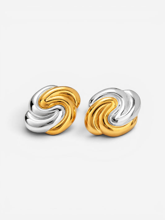 Gold and silver two-tone swirl earrings on white background