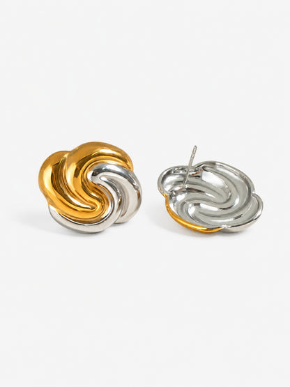 Close-up detail of two-tone swirl earrings with polished gold and silver finish