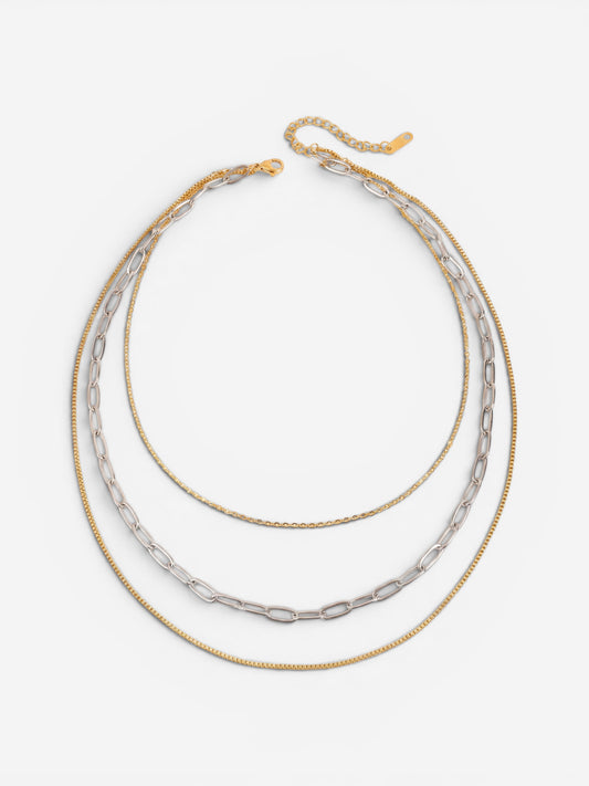 Gold and silver two-tone mixed chain layered necklace on white background