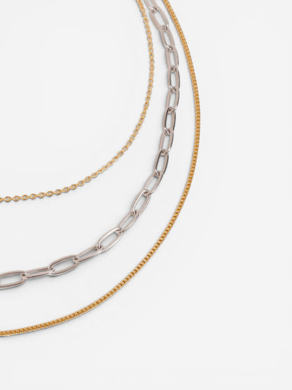 Close-up detail of gold and silver layered chain necklace