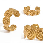 Multiple angles of abstract swirl open cuff bracelet gold pvd.