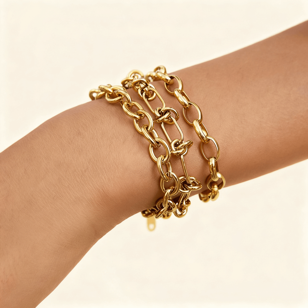Side view of a layered gold bracelet stack from The Amalfi Set on a model's arm, highlighting how the different chain textures and styles catch the light.