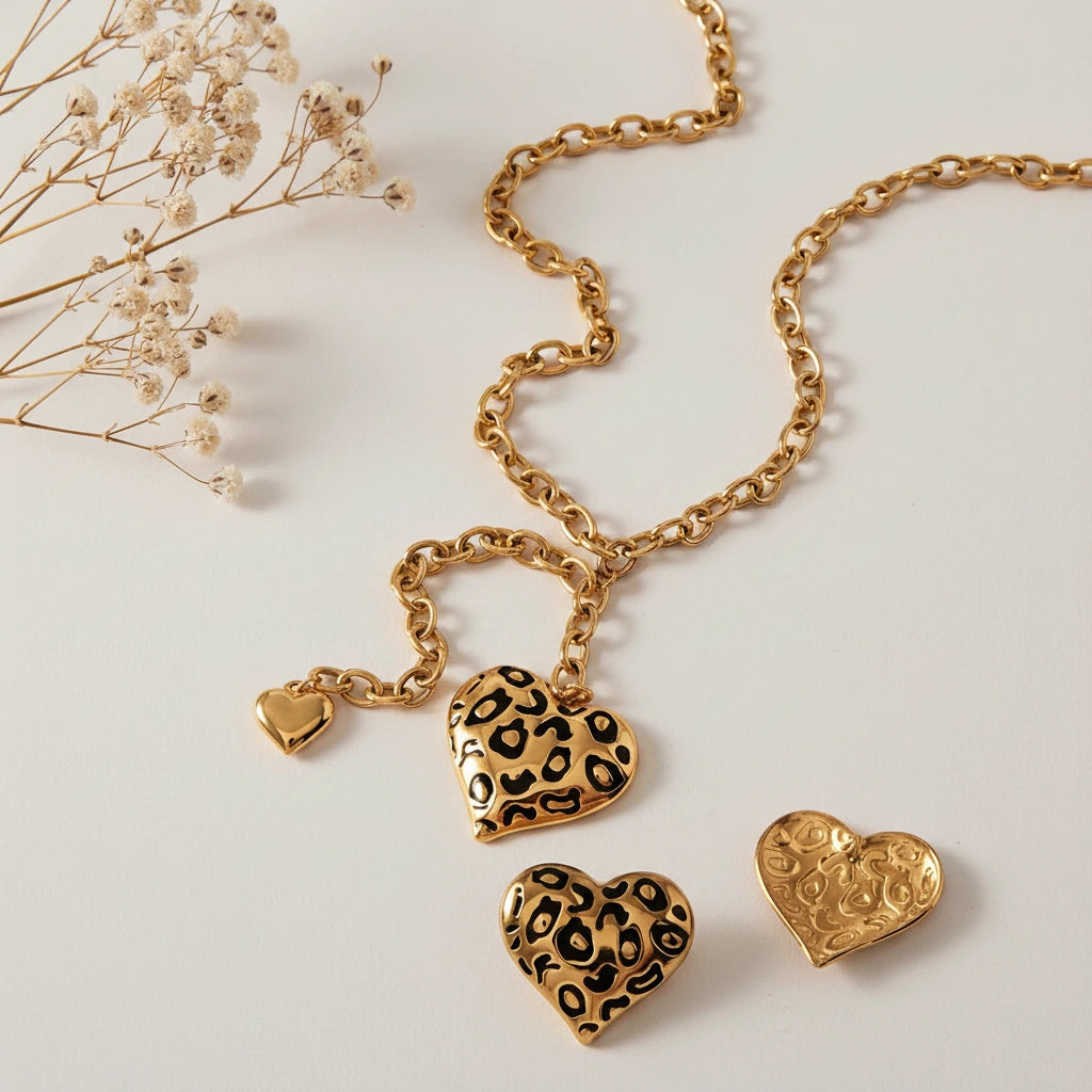 The Artemis leopard print heart necklace and matching earrings laid out to show their details, perfect for a bold, rock and roll style.
