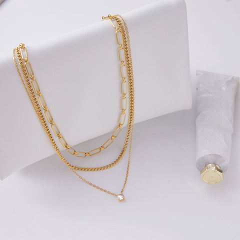 An artistic flat lay of The Charites Necklace styled with a modern lipstick, illustrating it as an essential accessory for everyday glamour.