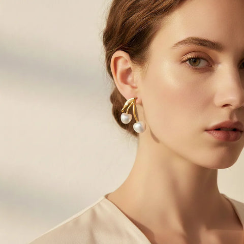 Side profile of a fair-skinned model wearing The Chérie Pearl Earrings, demonstrating how the sweet cherry design drops elegantly from the earlobe.