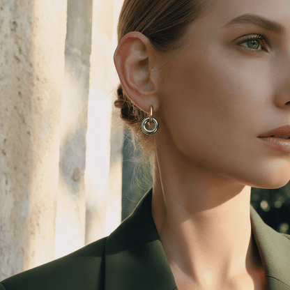 Close-up side profile of a woman wearing Luminova gold knot hoops, showcasing how they dangle from the ear.