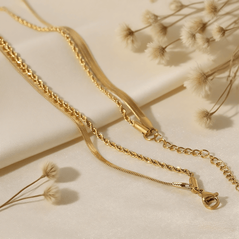 Classic Layered Chain Necklace — dual gold chains (herringbone + rope) on model neckline, elegant layering jewelry piece.