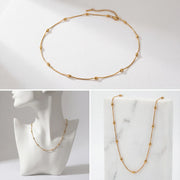 Aesthetic product photography of dainty gold beaded necklace on jewelry bust.