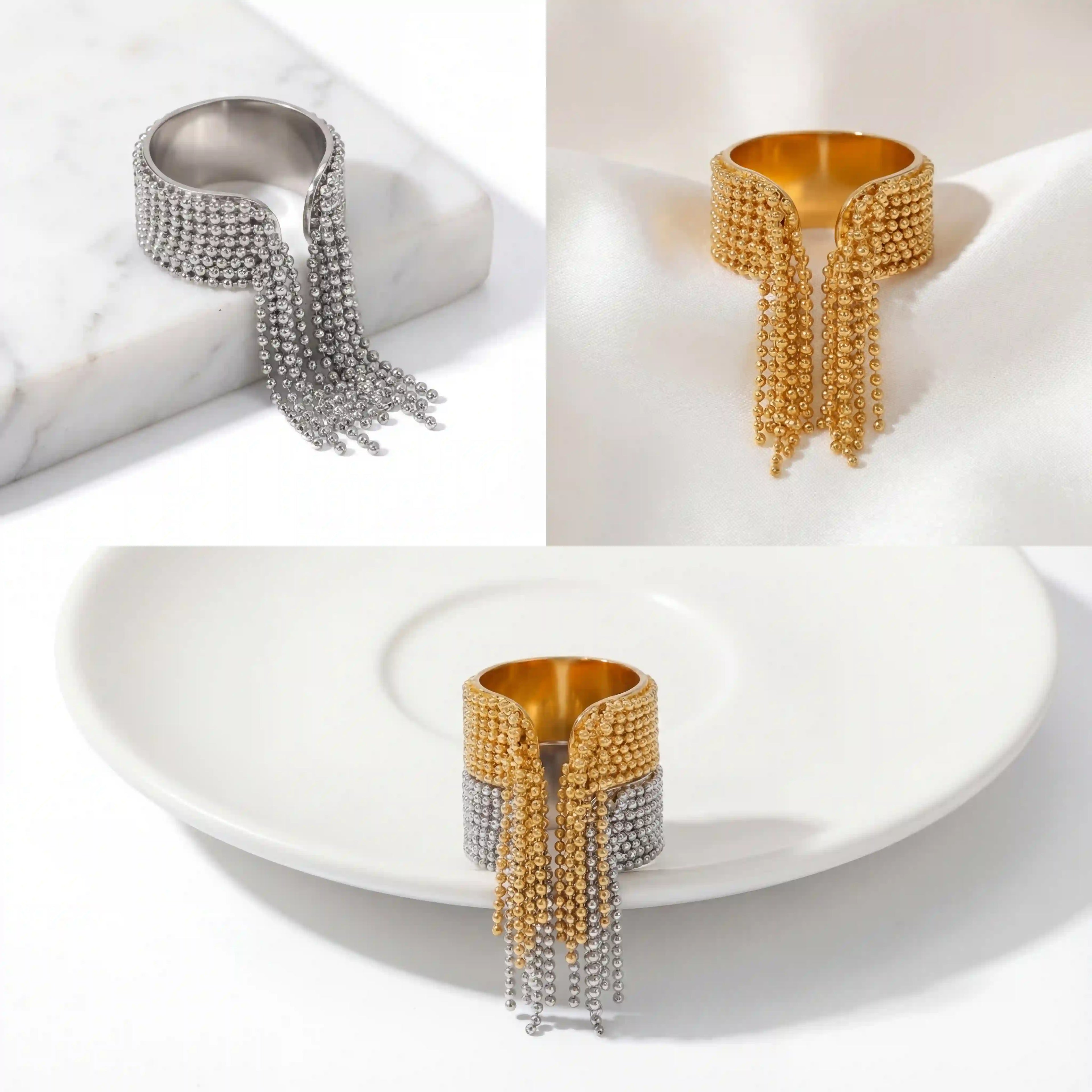 Aesthetic product photography of gold and silver chain tassel rings on marble.