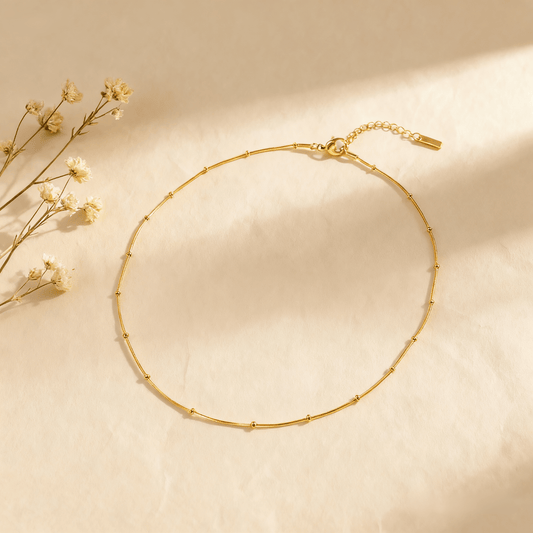 Luminova Dotted Bead Gold Necklace isolated on a white gold background, showcasing the delicate bead detail.