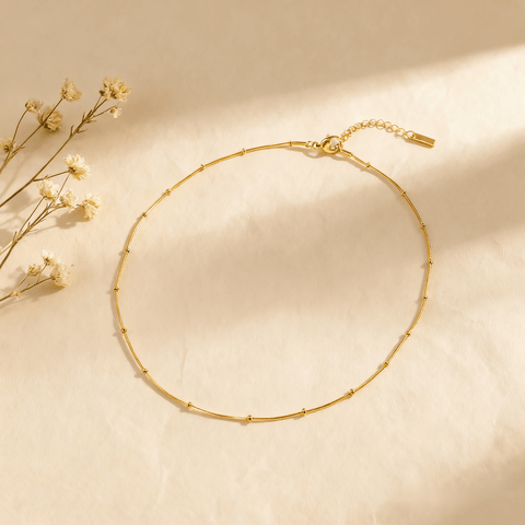 Luminova Dotted Bead Gold Necklace isolated on a white gold background, showcasing the delicate bead detail.