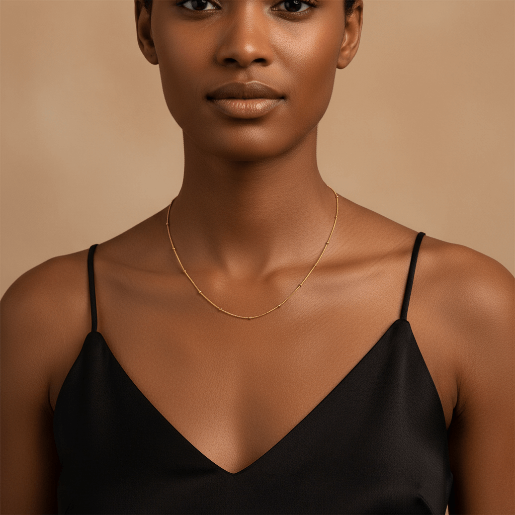 Woman wearing the Dotted Bead Chain Necklace alone as a minimalist choker with a black top.